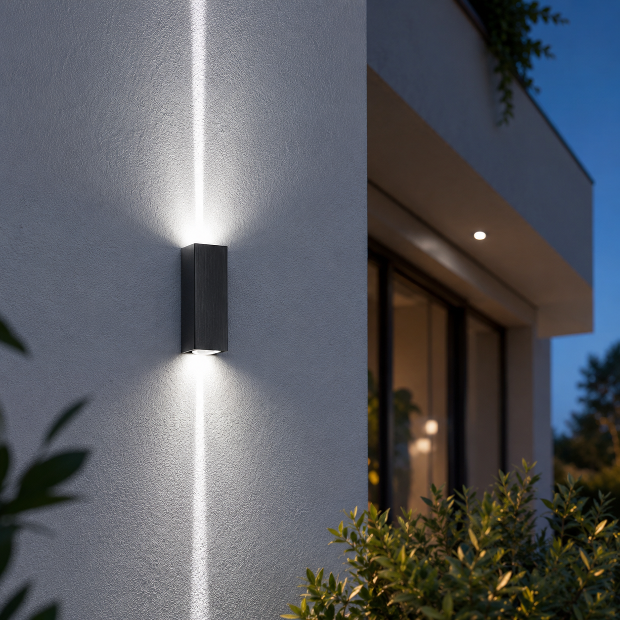 Lunara up and down wall light illuminating a modern patio wall with warm white lighting