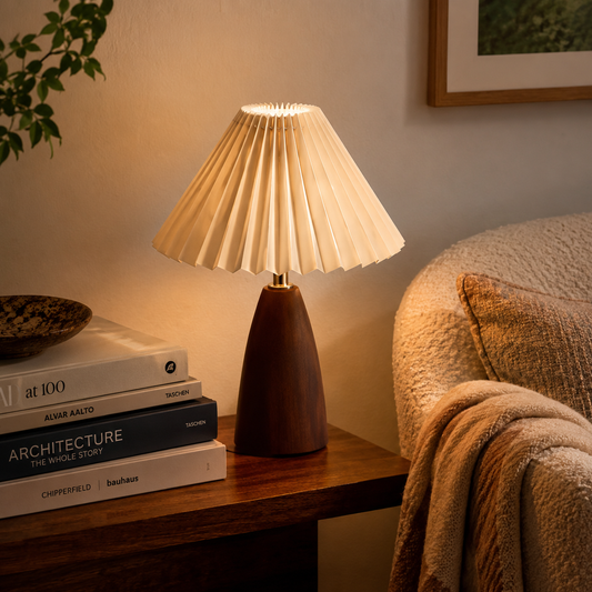 Marlow Pleated Wooden Table Lamp glowing warmly on a bedside table in a calm modern bedroom