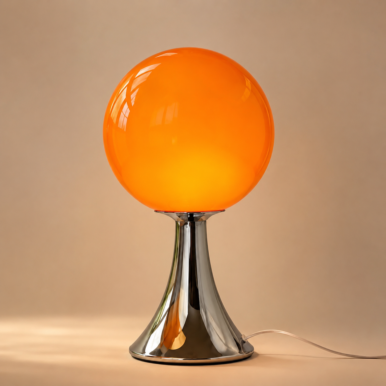 Orlena orange glass balloon table lamp on a neutral studio background